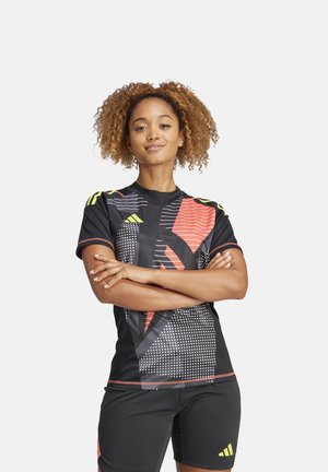 Zwart sportshirt met rode, gele en witte geometrische patronen. Korte mouwen, ronde hals, gecombineerd met zwarte shorts. Slanke pasvorm.