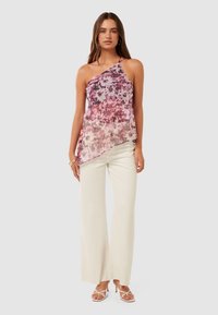 Asymmetrical, sheer top with a pink and purple floral pattern, paired with beige wide-leg trousers and strappy heels. Smooth texture, lightweight fabric.