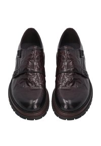 Bruine leren schoenen met een glanzende afwerking, voorzien van twee gespen en een dikke zwarte rubberen zool. Het ontwerp is strak met een ronde neus.