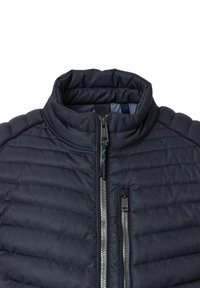 Marineblauwe gewatteerde jas met kraag, hoofdzakelijk en borst verticale zilveren ritsen, textuurstof en gewatteerd nekt ontwerp.