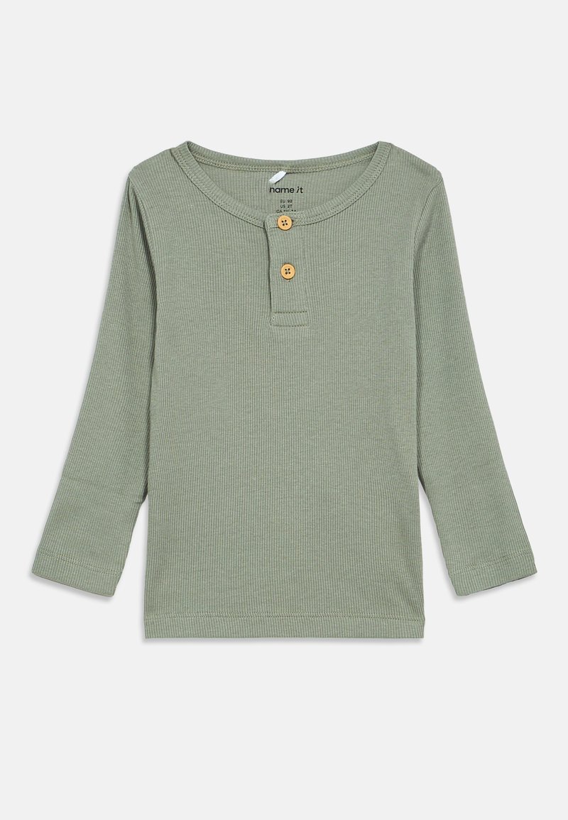 Μακρυμάνικη μπλούζα henley από μαλακό, ριγωτό ύφασμα. Χρώμα μουντό πράσινο με στρογγυλή λαιμόκοψη, δύο ξύλινους κουμπιά και ραμμένα χείλη.