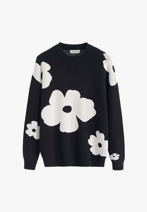 Pull noir avec un grand motif floral blanc. Il présente un col rond, des manches longues et des poignets côtelés. Texture douce et tricotée.
