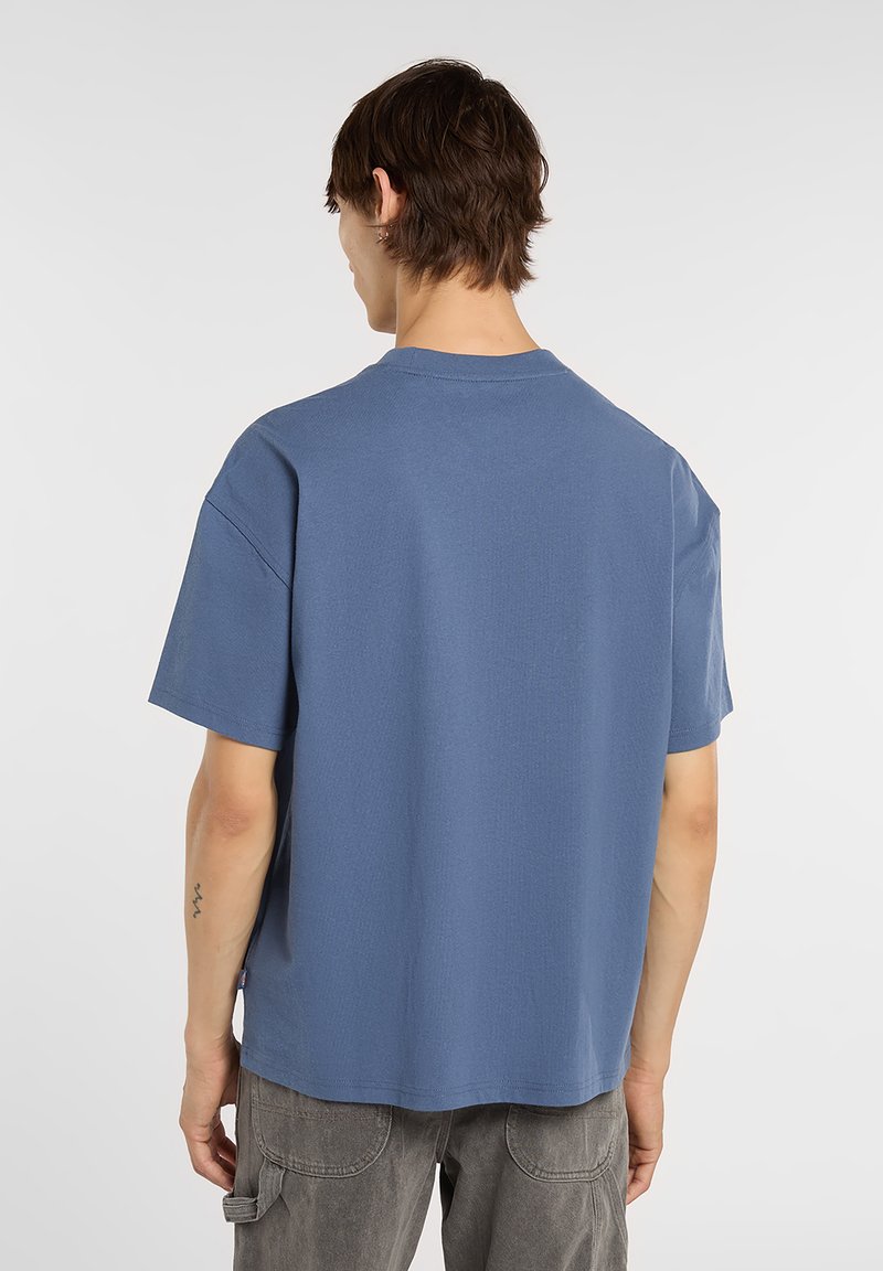 Blue short-sleeve t-shirt with a crew neck and loose fit, featuring a textured surface and a straight hem. Designed for casual wear.