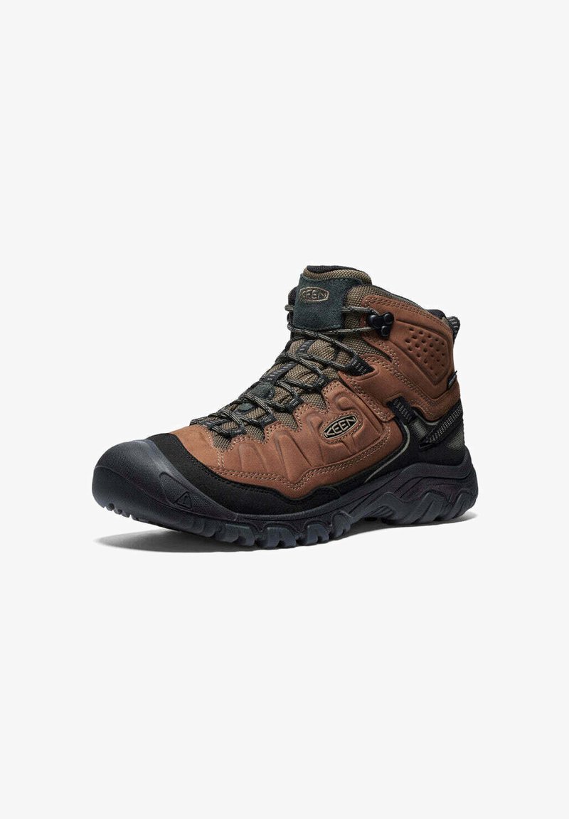 Bota de senderismo de caña alta en marrón y negro con suela texturizada, con cordones en la parte frontal y soporte acolchado para el tobillo, diseñada para su uso en exteriores.