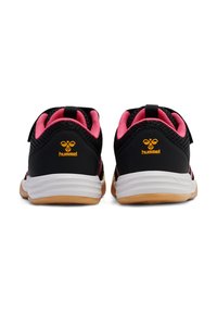 Chaussures de sport noires avec des accents roses, tige en maille, bande Velcro et semelle intermédiaire blanche ; dotées d'une semelle extérieure en caoutchouc gomme et d'un détail de logo.