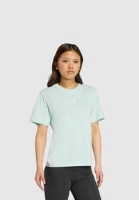 Camiseta verde menta de tela suave, con mangas cortas y cuello redondo. Pequeño logo centrado en el pecho. Bajo recto.
