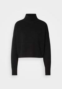 Pull noir court à col roulé avec manches longues et poignets et ourlet côtelés, avec un petit logo circulaire sur la poitrine gauche.