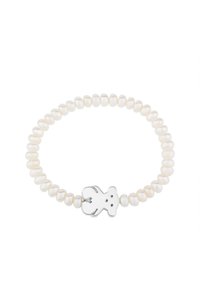 Pulsera de perlas con un diseño elástico, perlas blancas en forma ovalada y un charm de oso de plata en el centro.