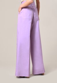 Lila wijde broek met een soepele textuur, hoge taille, twee achterzakken en gestikte details aan de zoom.