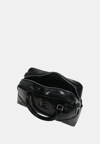 Borsa in pelle nera con chiusura a zip, forma arrotondata, manici doppi e effetto lettera in rilievo sulla parte anteriore. Contiene scomparti interni.