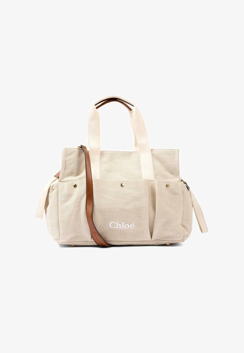 Sac fourre-tout en toile beige avec deux poignées supérieures, poches avant, bandoulière en cuir marron, et logo "Chloé" blanc sur la poche avant.
