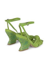 Sandali con zeppa in suede verde, con parte anteriore annodata, dettagli decorativi sulla zeppa e cinturini alla caviglia regolabili.