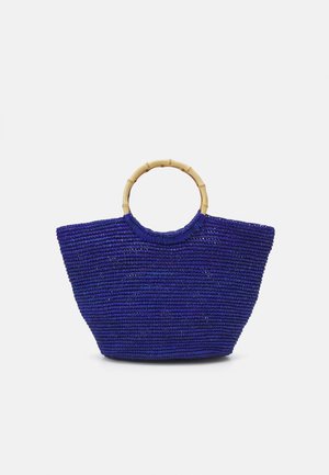 Sac à main tissé bleu avec une poignée en bambou. Présente une forme spacieuse et structurée ainsi qu'une surface texturée. Convient à une utilisation décontractée.