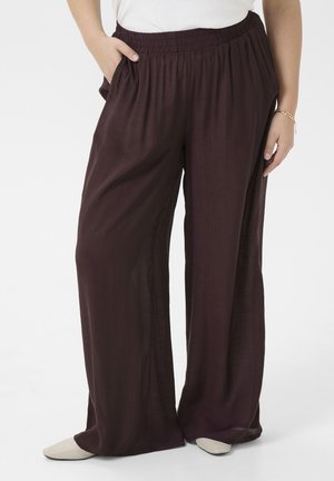 Loose, wide-leg pants in a deep burgundy fabric with a textured finish; features an elastic waistband and side pockets.
