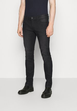 Svarta slim-fit jeans i denim, med framfickor, knäppning och lite stretch för komfort. Matchas med svarta stövlar.