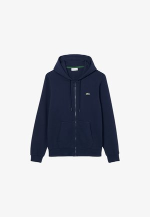 Felpa con cappuccio blu navy con zip, realizzata in tessuto morbido, con tasca a marsupio, cappuccio con coulisse e un piccolo logo verde sul petto.