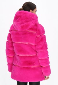 Pink fur coat with a hood, featuring a quilted design and soft texture. The coat has horizontal stripes and a slightly oversized fit.