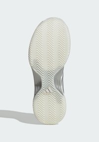 Podeszwa buta wykonana z białej gumy z wzorem jodełki oraz centralnym logo Adidas; gładka faktura, zakrzywiony kształt i wyraźne krawędzie.