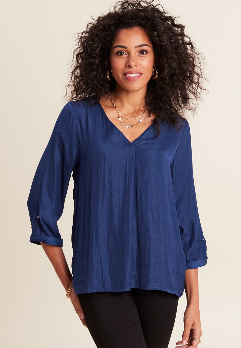Blusa leggera blu navy con scollatura a V e maniche a tre quarti, caratterizzata da polsini arrotolati e una texture liscia e setosa.
