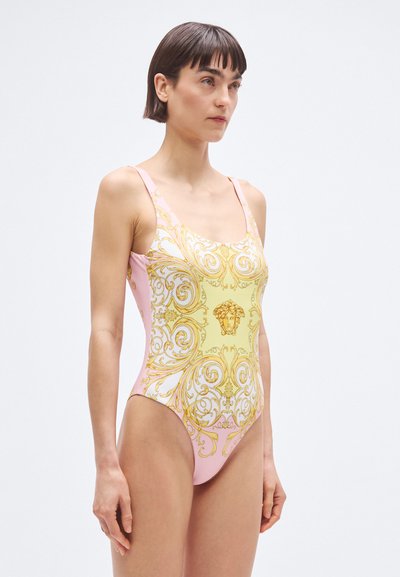 Ühetükkiline ujumistrikoo, millel on roosa ja kollane disain keerukate kuldsete barokkmustritega ning keskel asuva medaljoni detail.