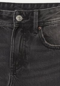 Jeans din denim negru cu un design clasic, având un nasture metalic, fermoar și o ușoară decolorare pe întreaga țesătură. Buzunarul frontal este vizibil.