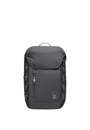 Sac à dos rectangulaire gris foncé avec poche zippée à l'avant, rabat supérieur, boucles latérales et logo "GOT BAG" en bas à droite.