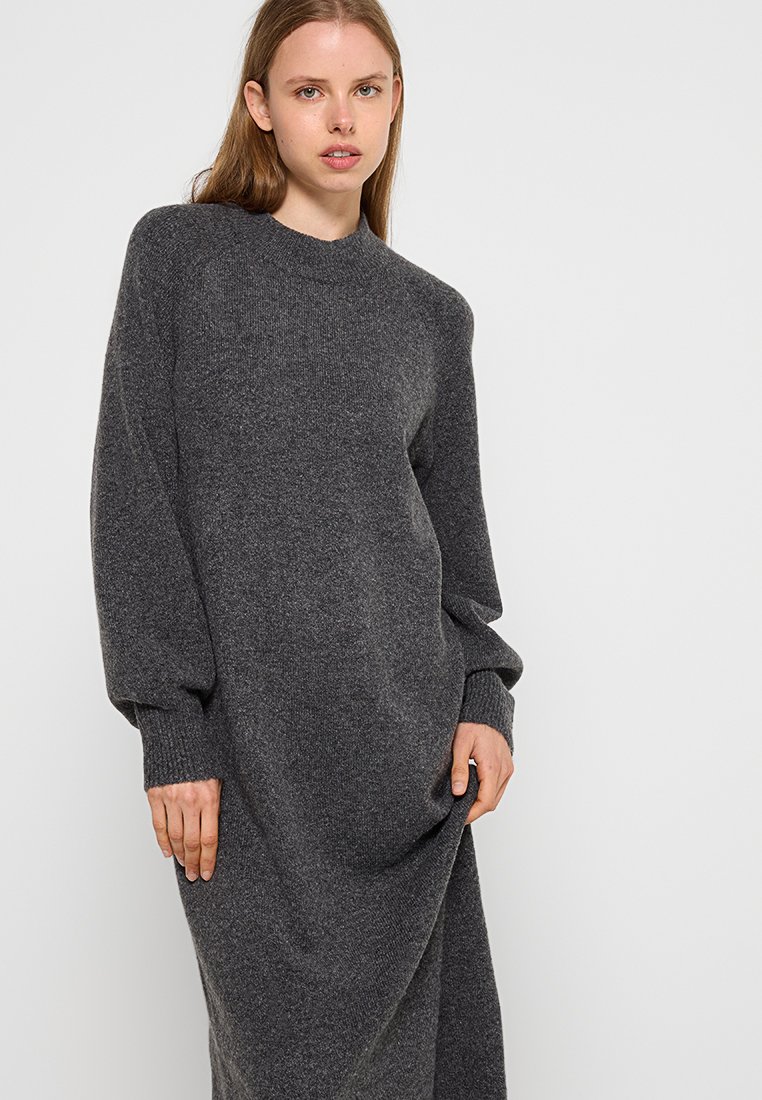 Langes graues Strickkleid mit Rundhalsausschnitt und eng anliegenden Bündchen, das einen lockeren Schnitt und eine weiche Textur aufweist. Ideal für die Freizeit.