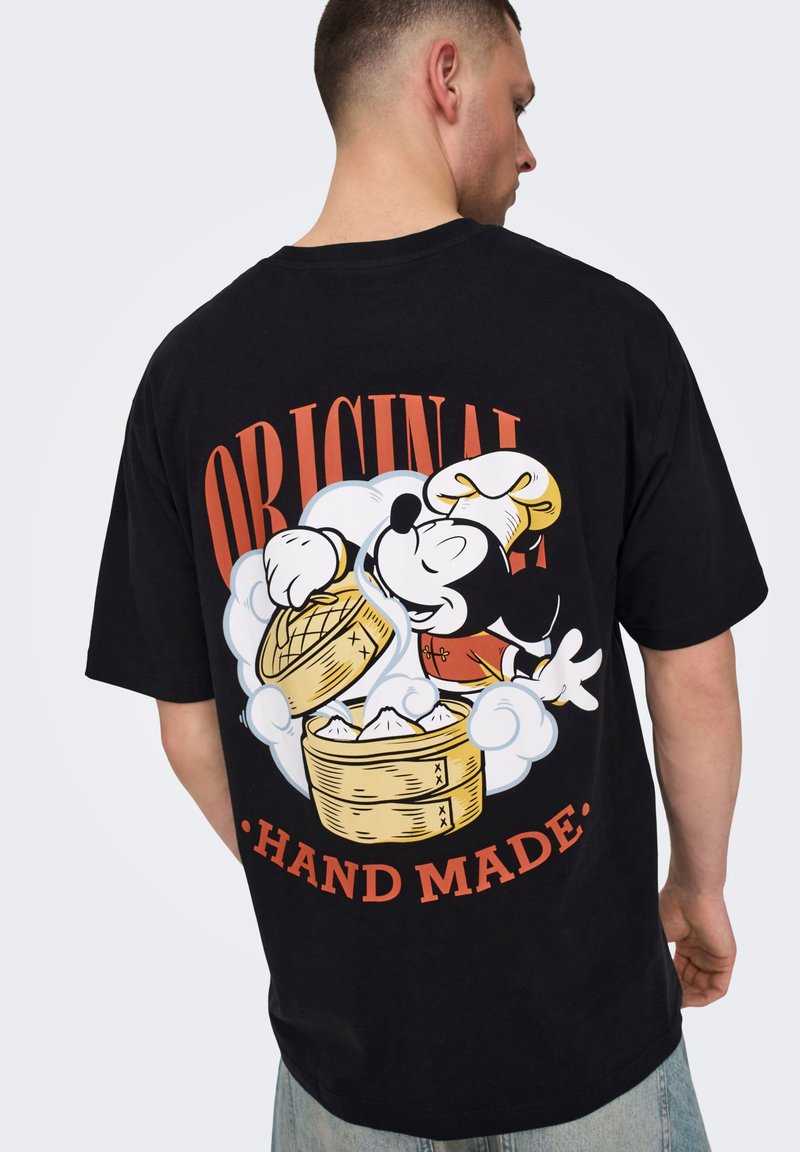 Fekete pamut póló, színes grafikával egy séf követ znajdujával, a szöveg: "ORIGINAL HAND MADE" narancsszínben.