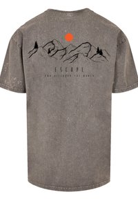 Graues kurzärmeliges T-Shirt mit einem schwarzen Berglandschaftsdesign und einer orangefarbenen Sonne darüber, sowie dem Wort "ESCAPE" in fetten Buchstaben.