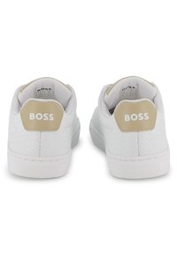 Λευκά αθλητικά παπούτσια με υφή δέρματος, μπεζ λεπτομέρειες και το λογότυπο "BOSS" στη φτέρνα. Επίπεδη ελαστική σόλα, κλασικός σχεδιασμός χαμηλού μέσου.