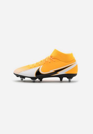 Crampon de football jaune et blanc avec un motif d’éclair noir et blanc, des lacets et un col de chaussette à la cheville sur fond blanc.