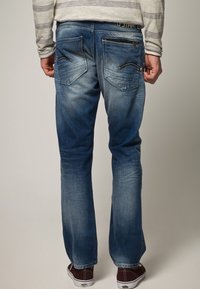 Siniset farkut, joissa on suora lahje, haalistumat reisissä ja kaksi takataskua, joissa on erityiset ompelu yksityiskohdat.