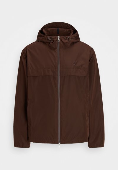 Brun lett jakke med hette, glidelås foran og elastiske mansjetter. Har to sidelommer og en subtil logo-detail på brystet.
