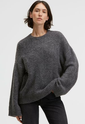 Übergroßer grauer Pullover aus strukturiertem Strickmaterial, mit einem gerippten Ausschnitt und Bündchen, fallenden Schultern und einer lockeren Passform.