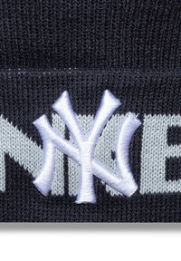 Námornícky pletený klobúk s bielou výšivkou loga New York Yankees a svetlošedým textom na obvode, s jemným, textúrovaným povrchom.