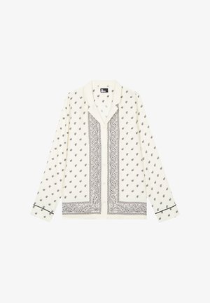 Chemise blanche à manches longues à boutons avec motifs paisley noirs et bordures, dotée d'un col classique et d'un liseré noir sur les poignets.