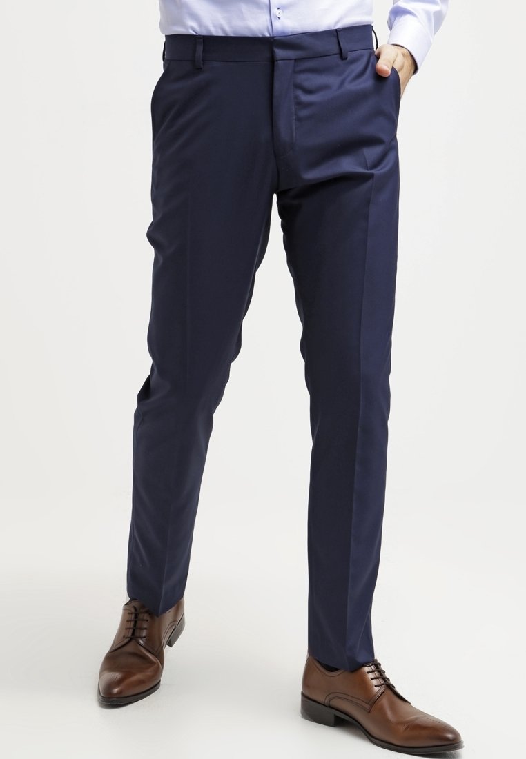 Navy trousers made of a smooth fabric, featuring a straight cut, front pockets, and a discreet waistband, paired with brown shoes.