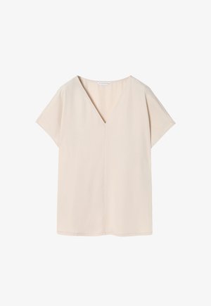 Top corto de manga corta en color beige, hecho de una tela suave, con escote en V y un corte holgado, terminando en un dobladillo recto y un diseño minimalista.