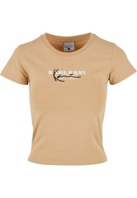 Beige bomull t-skjorte med en tettsittende design. Har rund halsutringning og korte ermer. Fronten viser "KARL KANI" i hvit tekst med svarte detaljer.