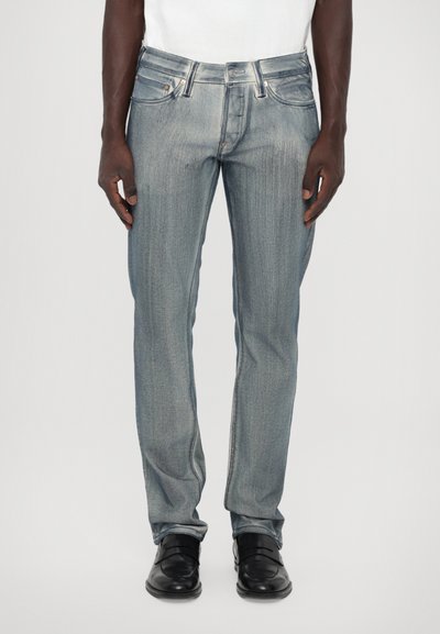 Light blue denim jeans with straight fit, five pockets, belt loops, and subtle faded texture. Paired with black dress shoes.