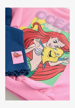 Rožinė treninginė palaidinė su užrašu "OCEAN VIBES" ir pieštuku pavaizduota undinė, derinama su mėlynomis klostuotomis legginsais ir rožiniu žymekliu su personažo iliustracija.