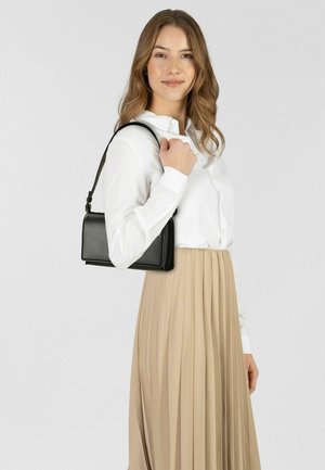 Schwarze rechteckige Handtasche aus strukturiertem Material mit Schulterriemen, präsentiert mit einem hellfarbenen plissierten Rock und einer weißen Bluse.