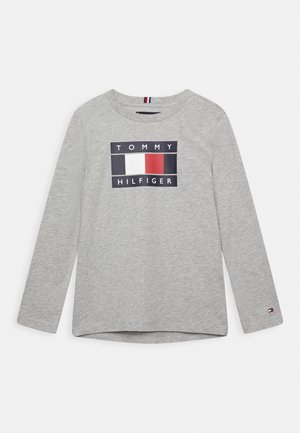 Lysegrå langærmet skjorte med Tommy Hilfiger-logo, der viser en hvid, rød og mørkeblå rektangel centreret på brystet.