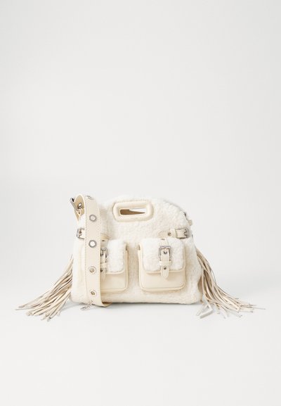 Borsa con texture in pelliccia bianca, dotata di due tasche frontali, accessori in argento e una tracolla frangiata. Accenti in pelle liscia e manico superiore.
