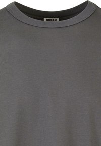 T-shirt gris à col rond avec un col intérieur noir et une étiquette "URBAN" cousue dans le décolleté.