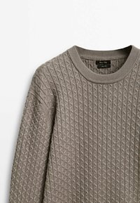 Maglione grigio lavorato a maglia con un motivo a diamante testurizzato, collo a giro ribbed e maniche lunghe. Il tessuto sembra morbido e caldo.