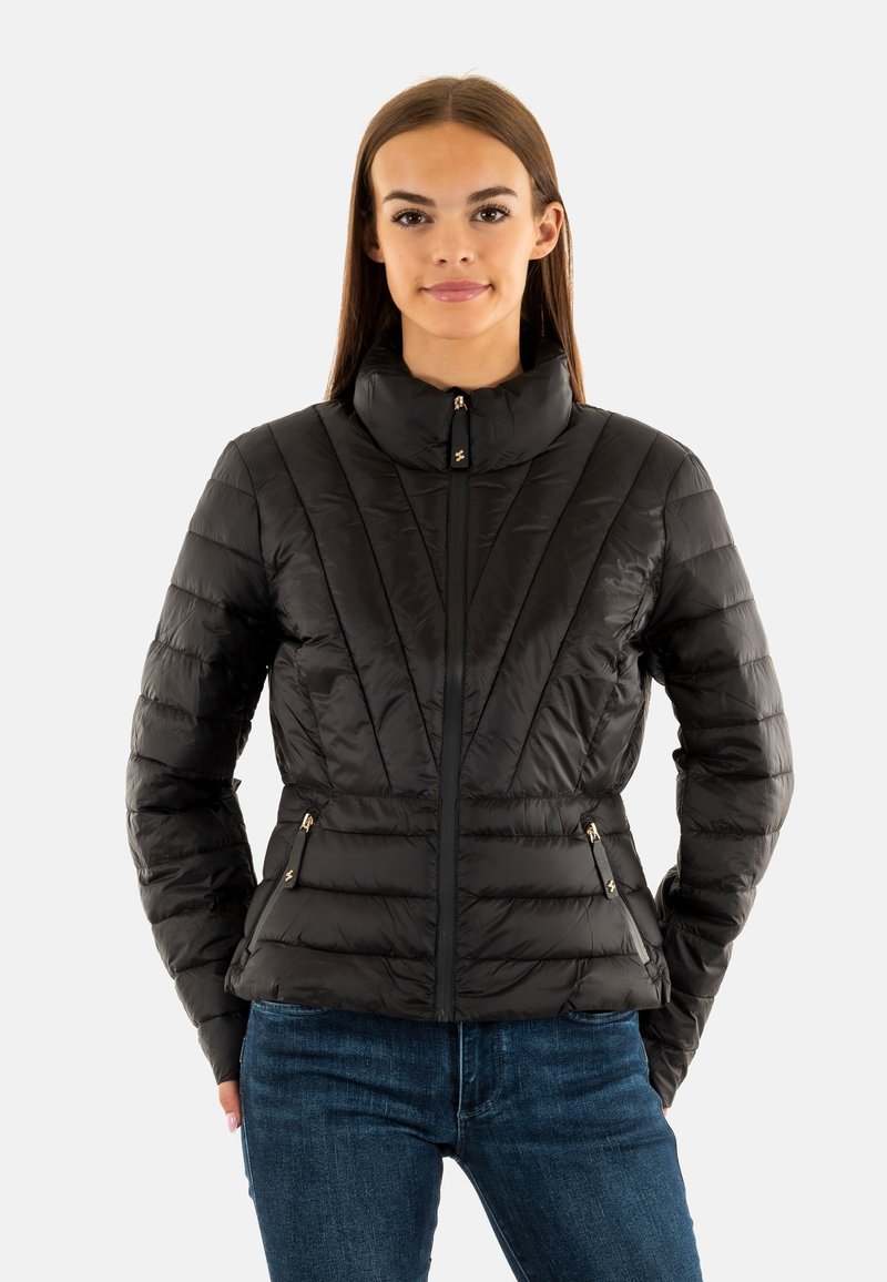 Giacca isolante nera con colletto alto, motivo a righe verticali, tasche con zip e dettagli in hardware dorato.
