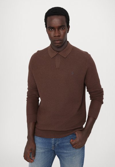 Brun strikket polo shirt med krave og lange ærmer, med en subtil tekstur og et lille logo på brystet, parret med blå jeans.