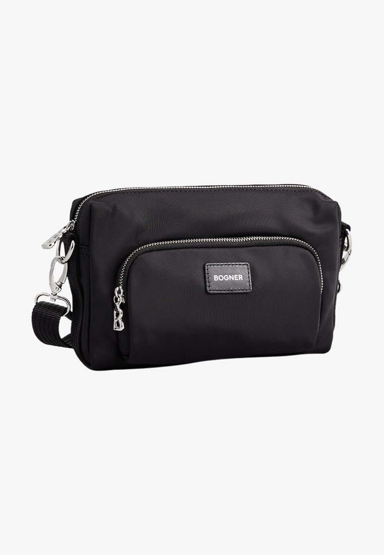 Bolsa bandolera de nailon negra con cremalleras en tono plateado, bolsillo frontal con cremallera y un parche con el logo. Cuenta con una correa ajustable y una textura suave.