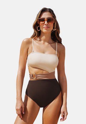 High-waisted bikini in beige and brown. The top features a strappy design with an angled cut. A decorative belt with an accent detail is included.